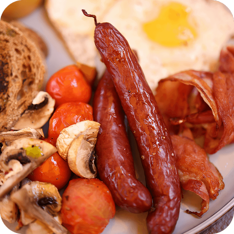 A plate of food with sausage, eggs and mushrooms.