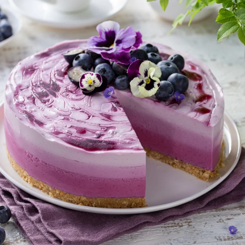 Layered blueberry cheesecake with pansies.